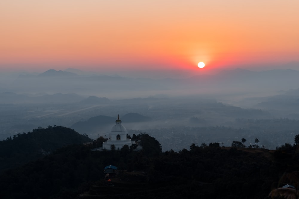 white concrete building on top of mountain during sunset