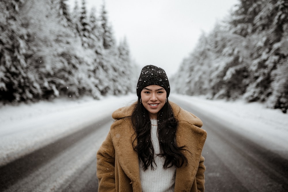 woman in brown coat standing on road during daytime