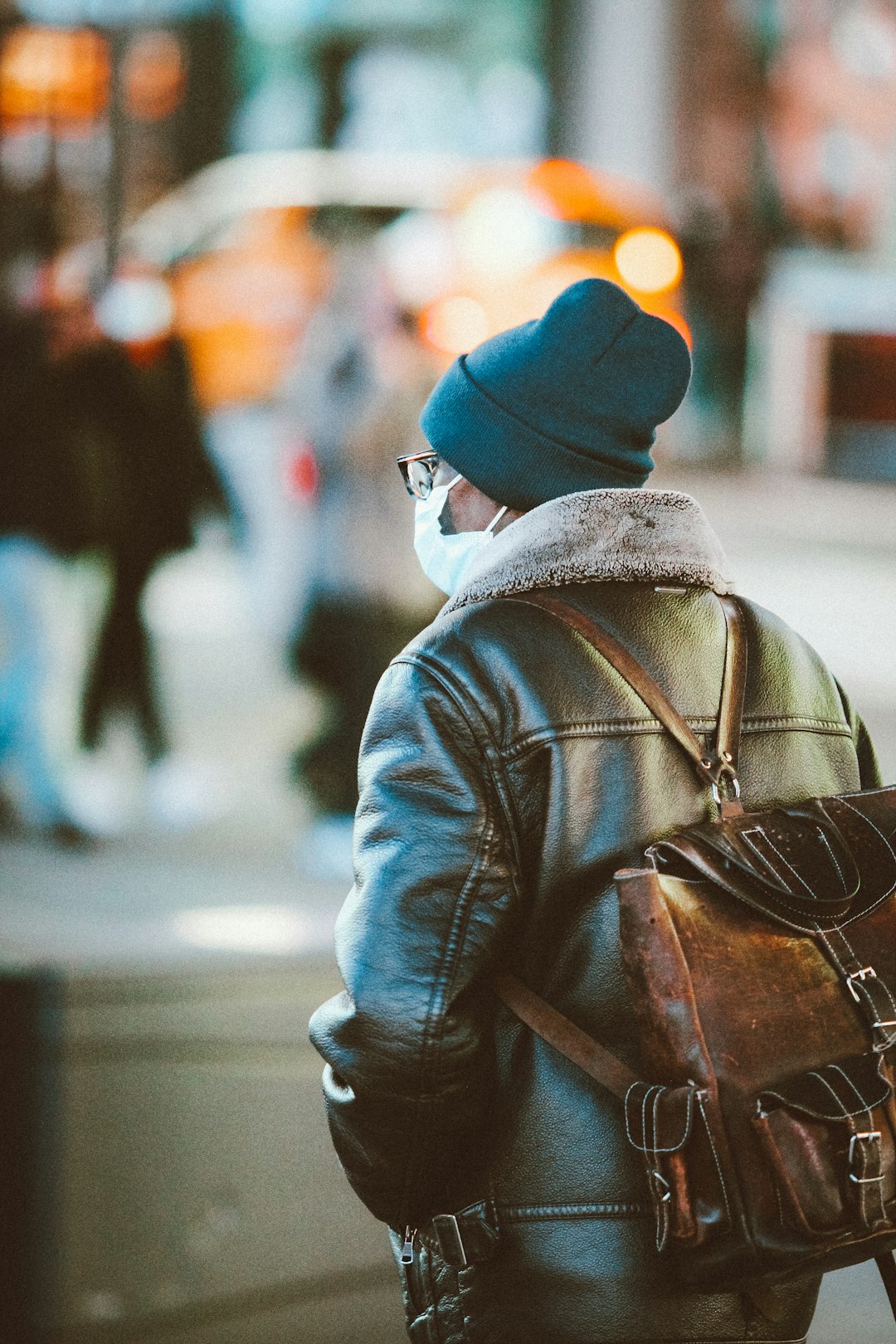 man in blue knit cap and blue jacket walking on street during daytime