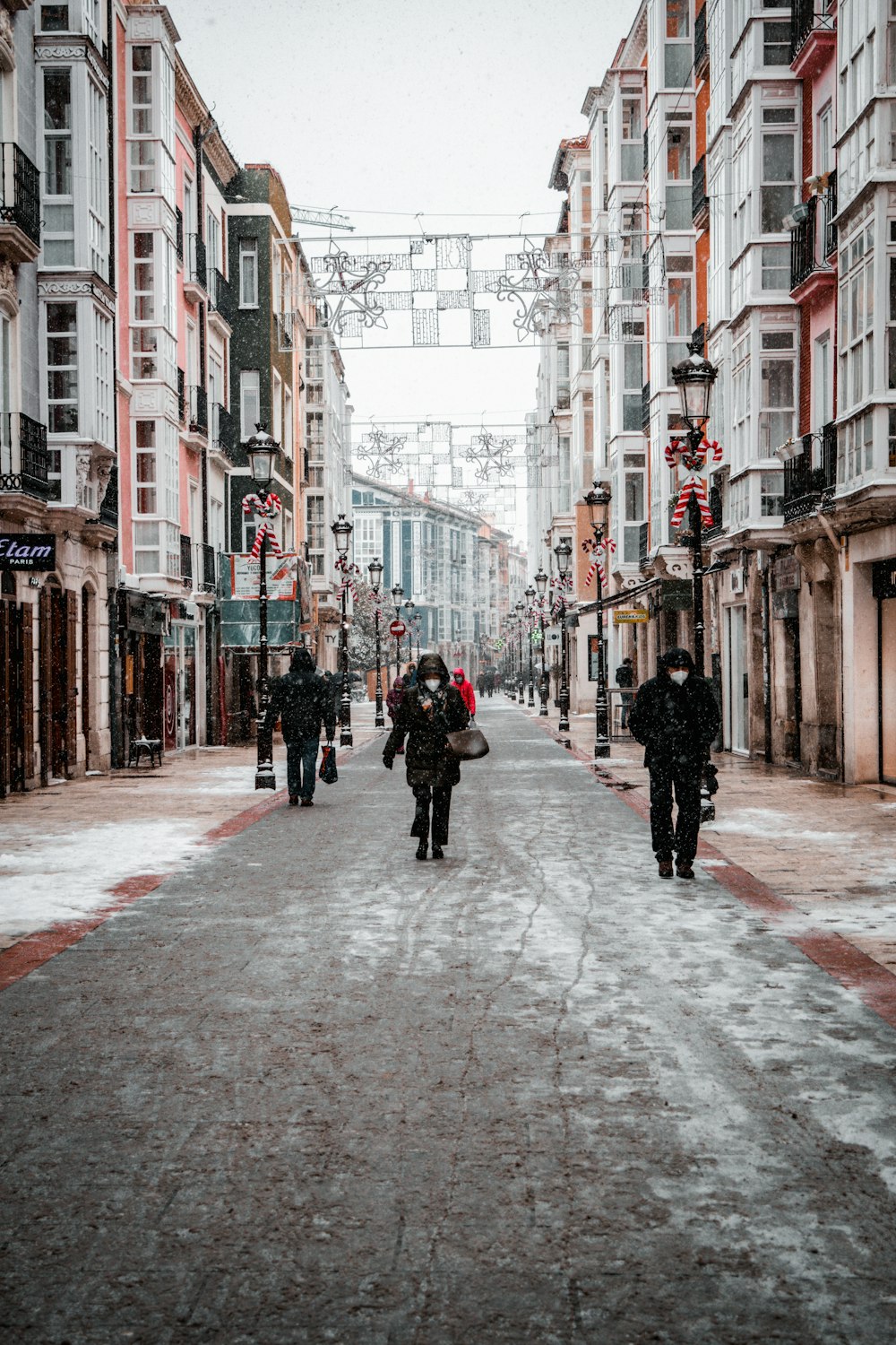 people walking on street between buildings during daytime