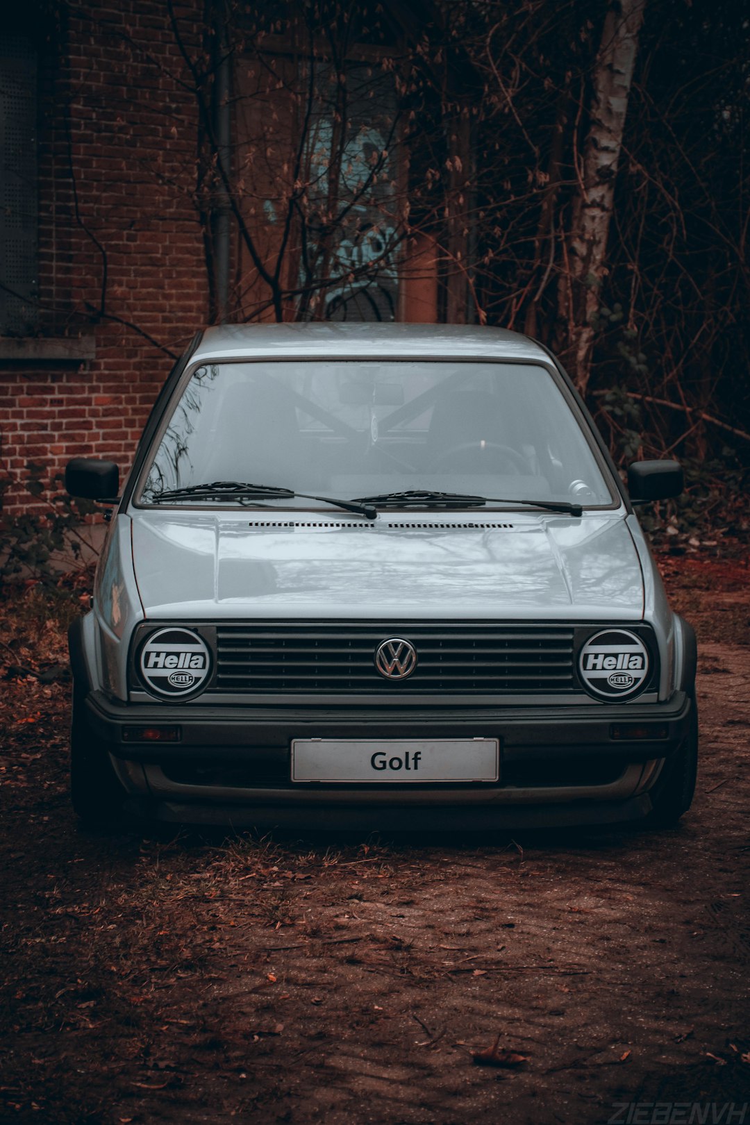 white volkswagen car parked beside brown brick wall