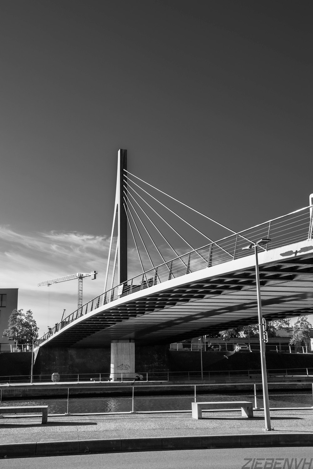 Graustufenfoto der Brücke unter bewölktem Himmel