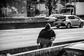 man in black jacket and black knit cap standing on road