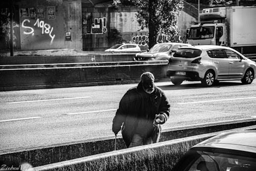 man in black jacket and black knit cap standing on road