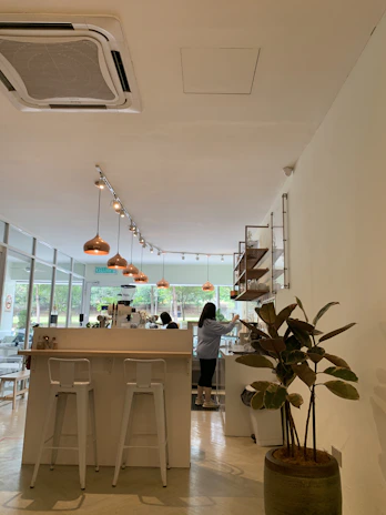 Transformation of a café interior showing new plaster walls and stylish lighting installation.