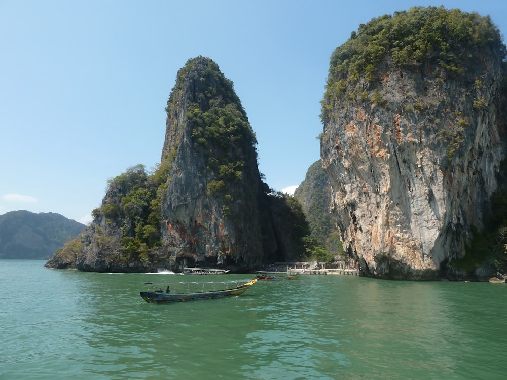 boat on sea near rock formation during daytime