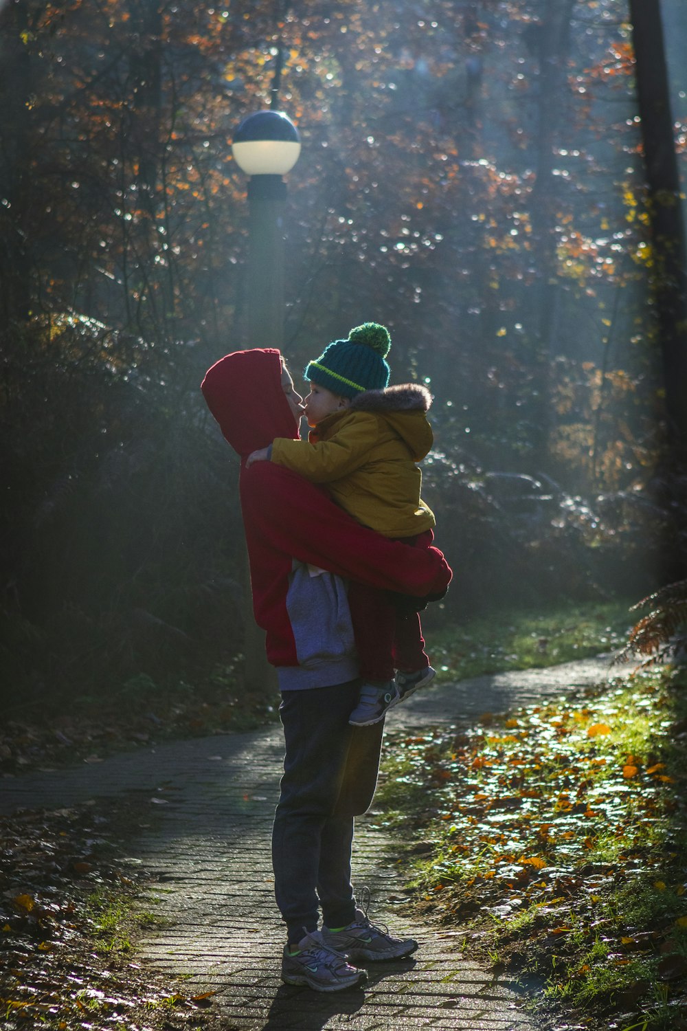 person in red hoodie and blue denim jeans standing on forest during daytime