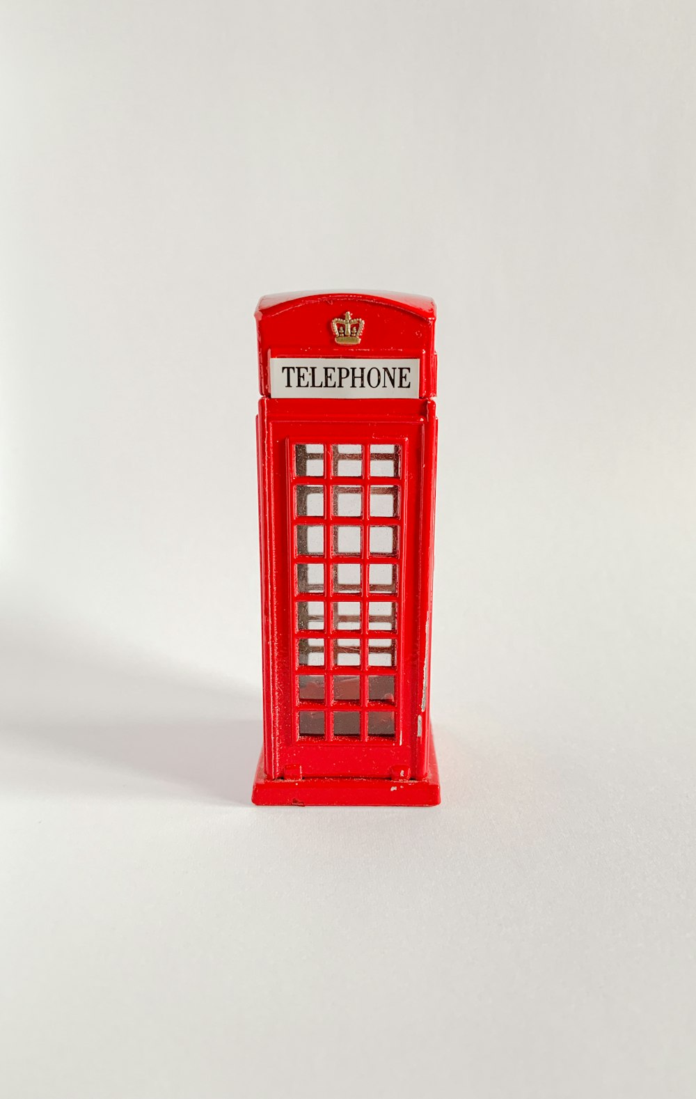 白いテーブルの上に赤い電話ボックス