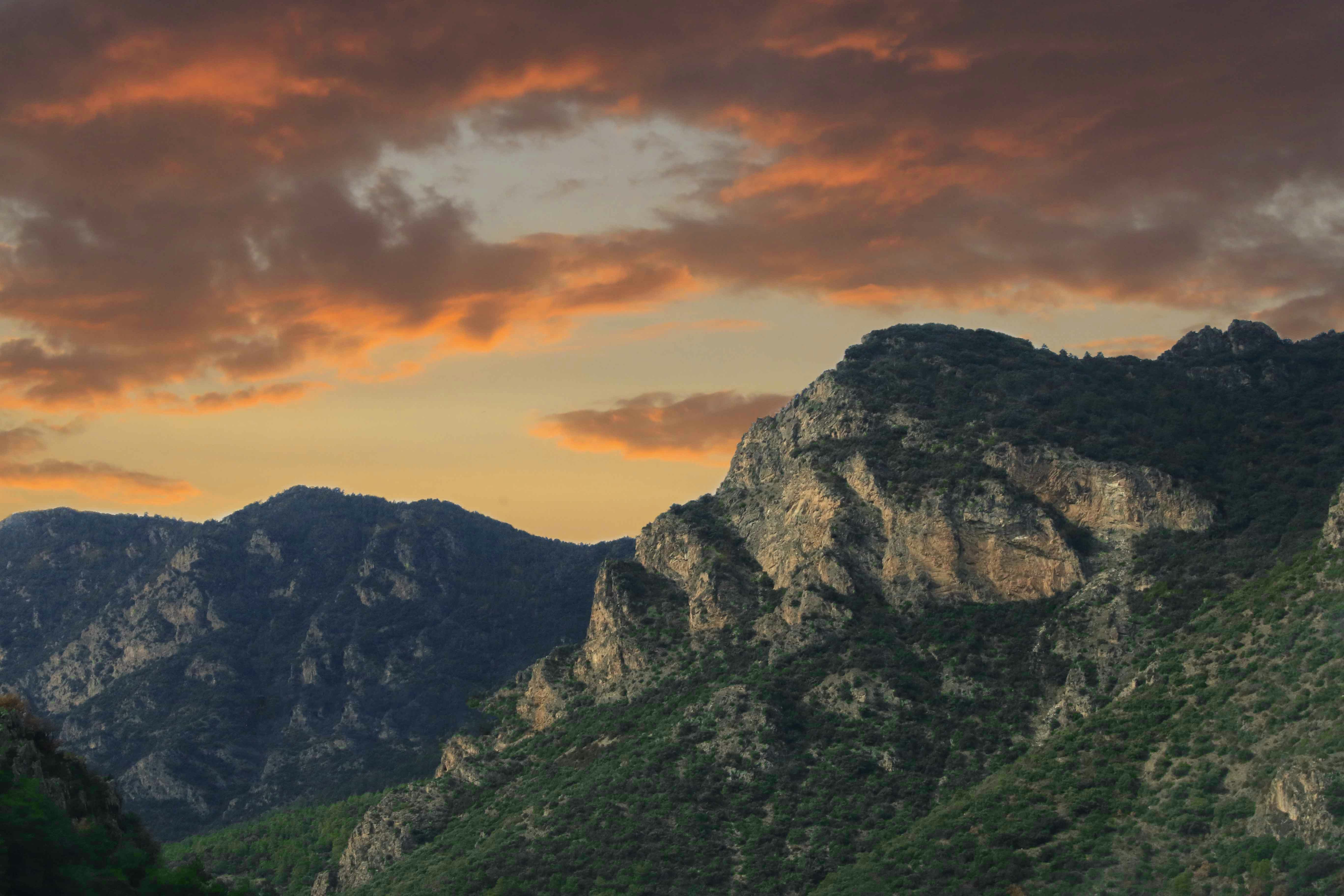 green and brown mountain under cloudy sky during daytime