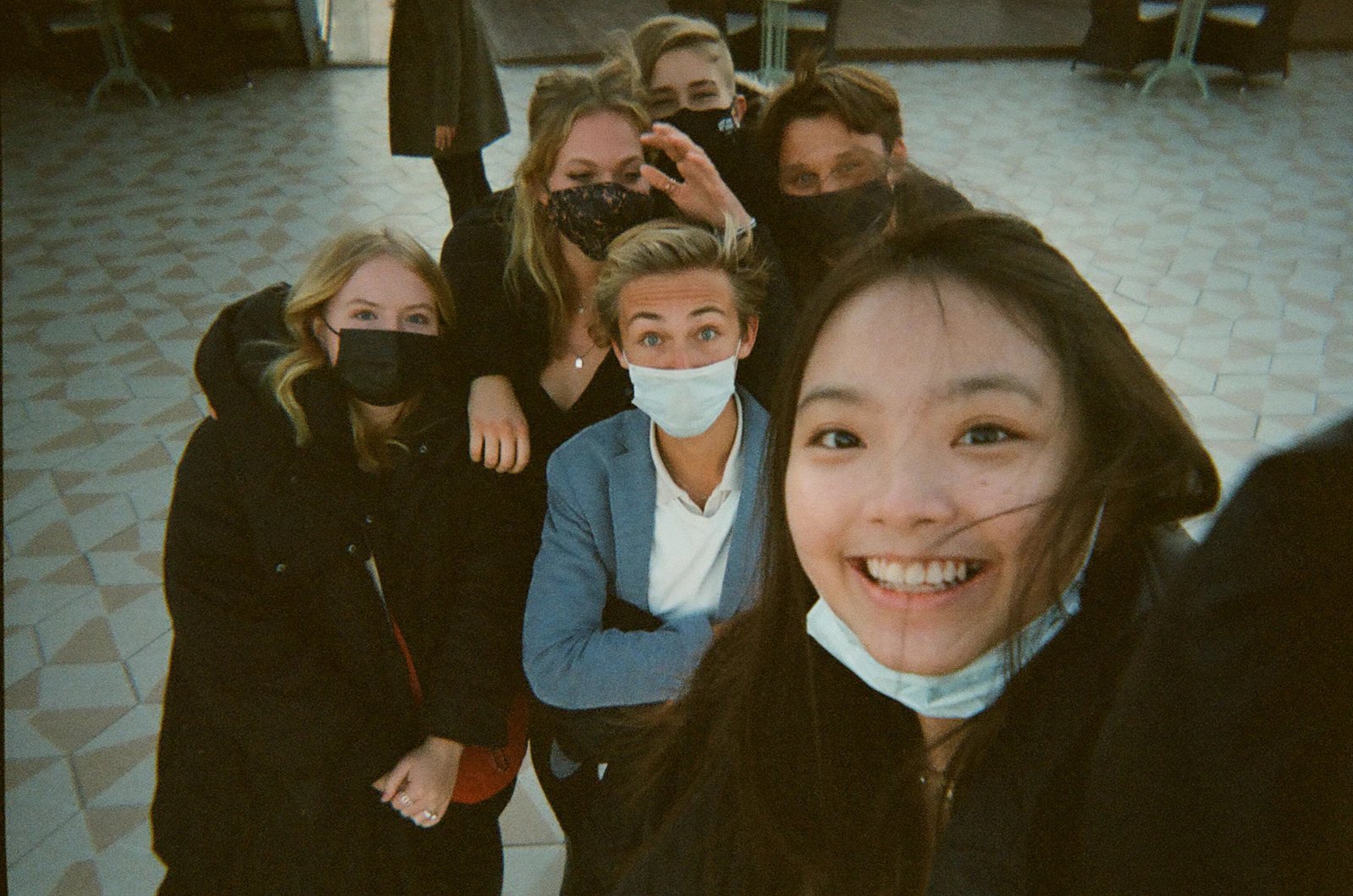 Groupe d'amis prenant une photo ensemble avec un smartphone.