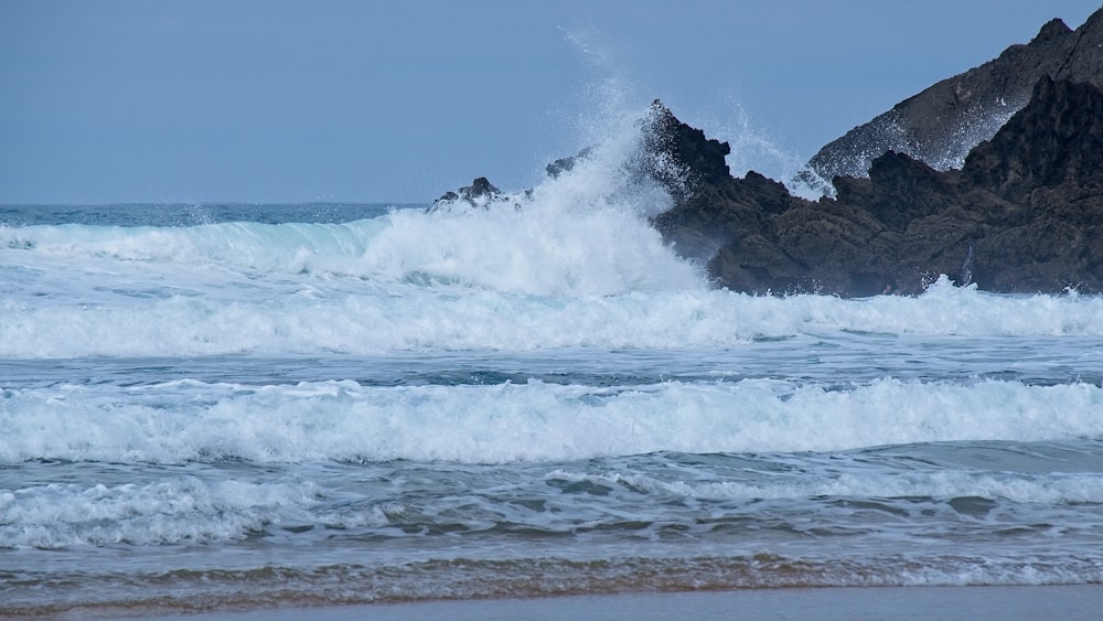 ocean waves crashing on shore during daytime