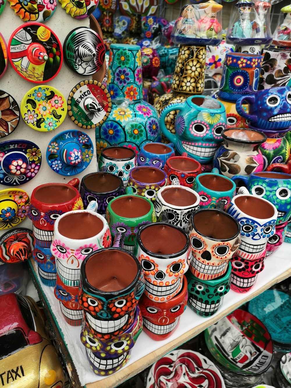 multi colored ceramic mugs on white shelf