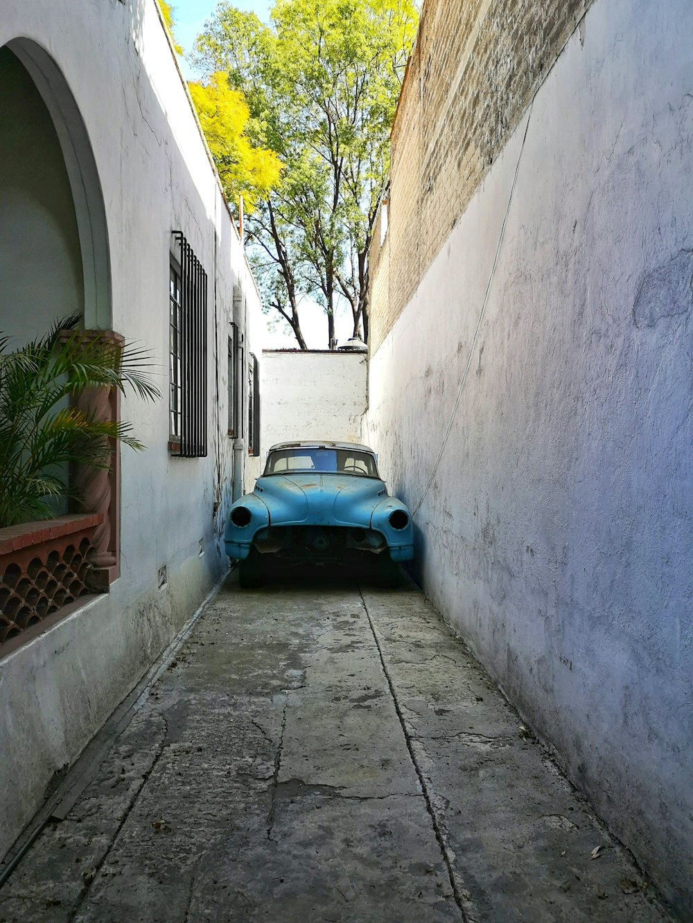 blue car parked on gray concrete pathway