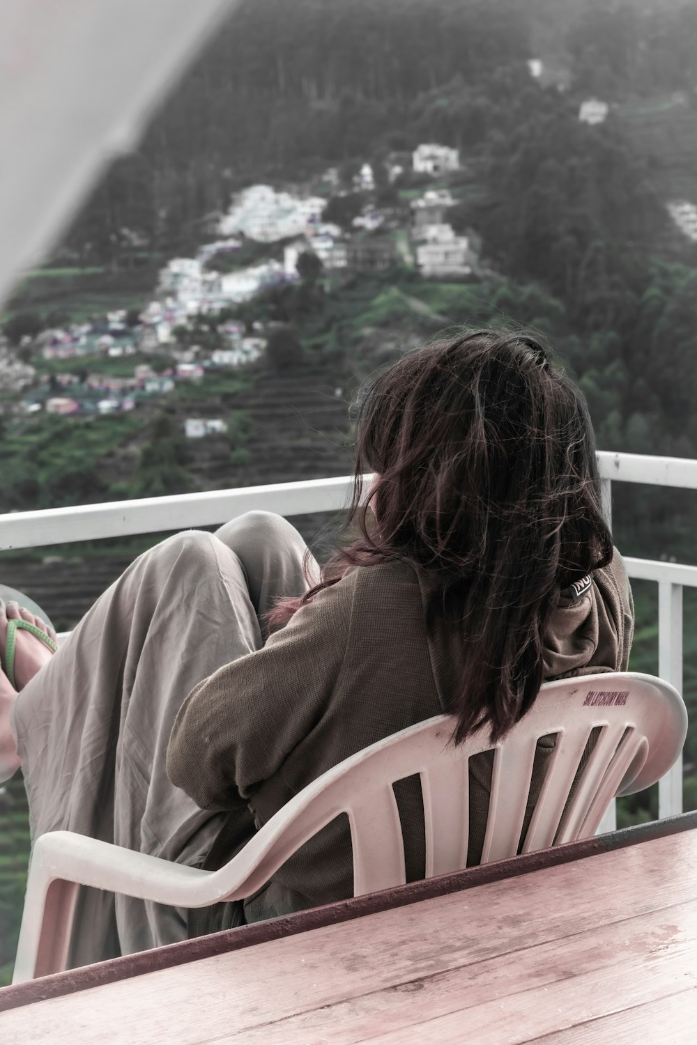 woman in brown hoodie sitting on white wooden chair