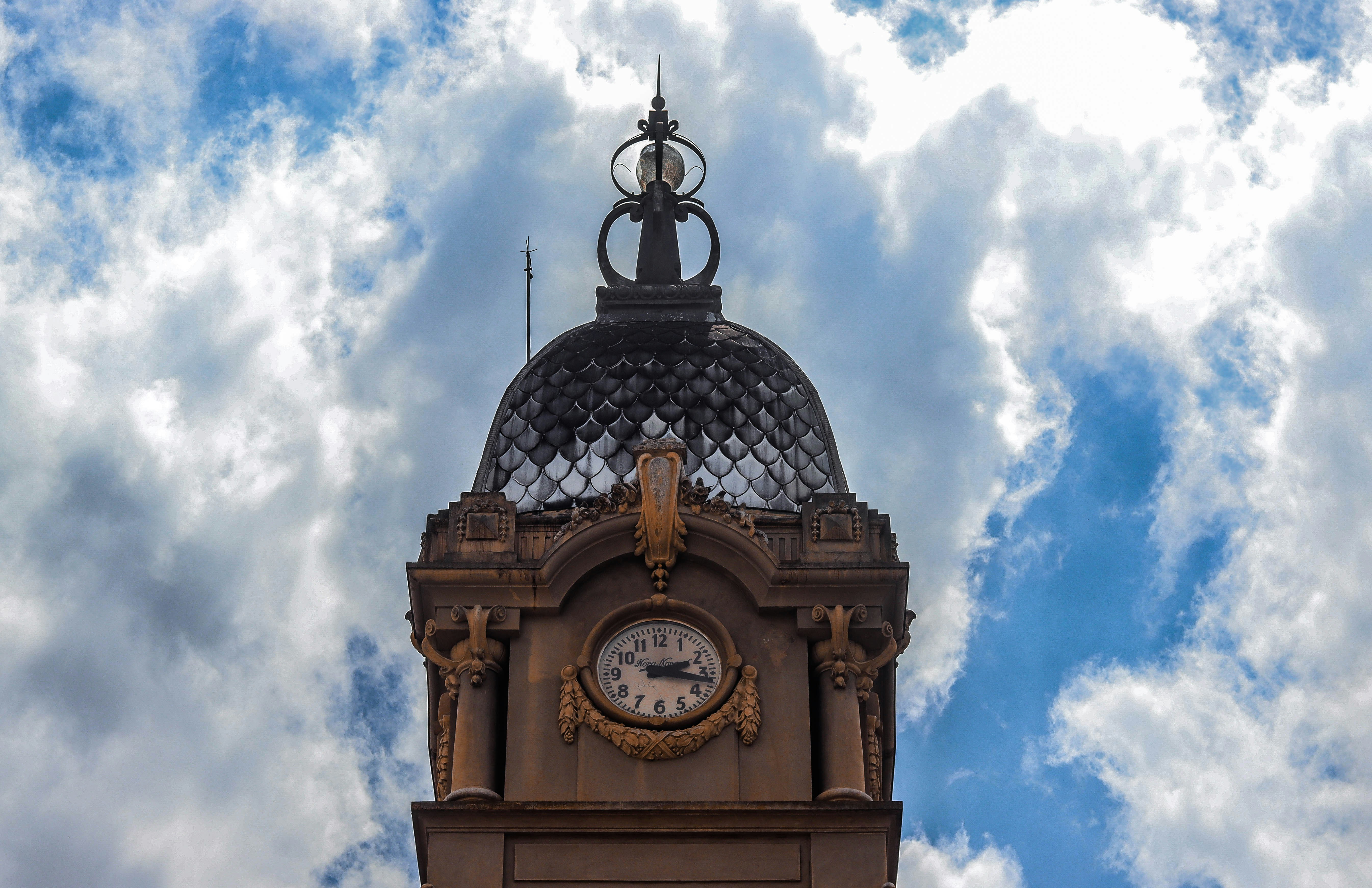 brown and black concrete building under white clouds during daytime, 