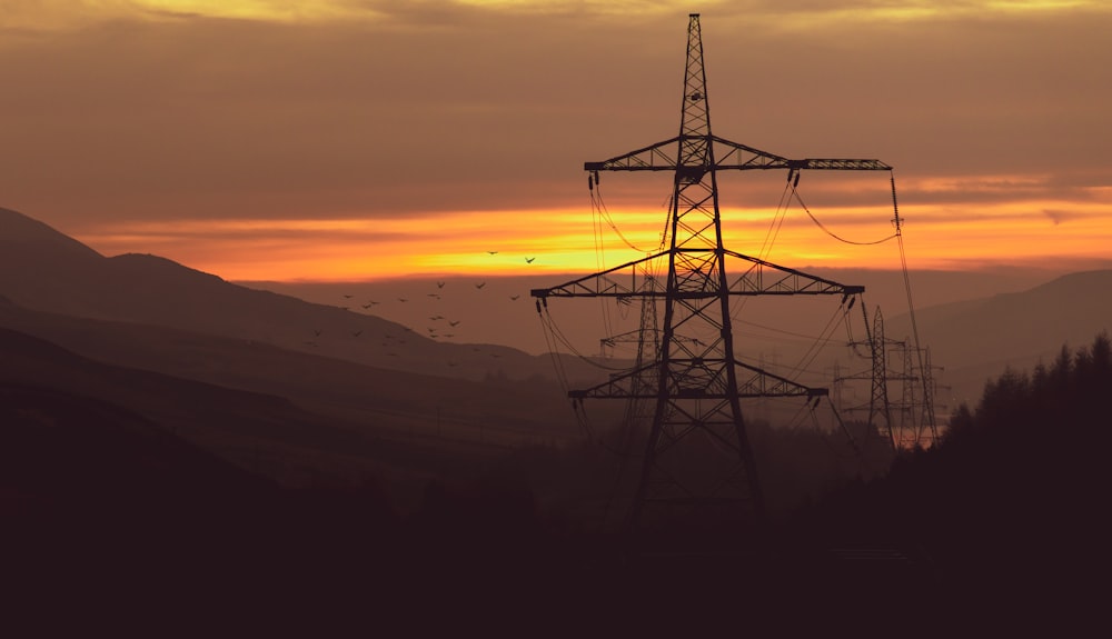 black metal tower on top of mountain during sunset