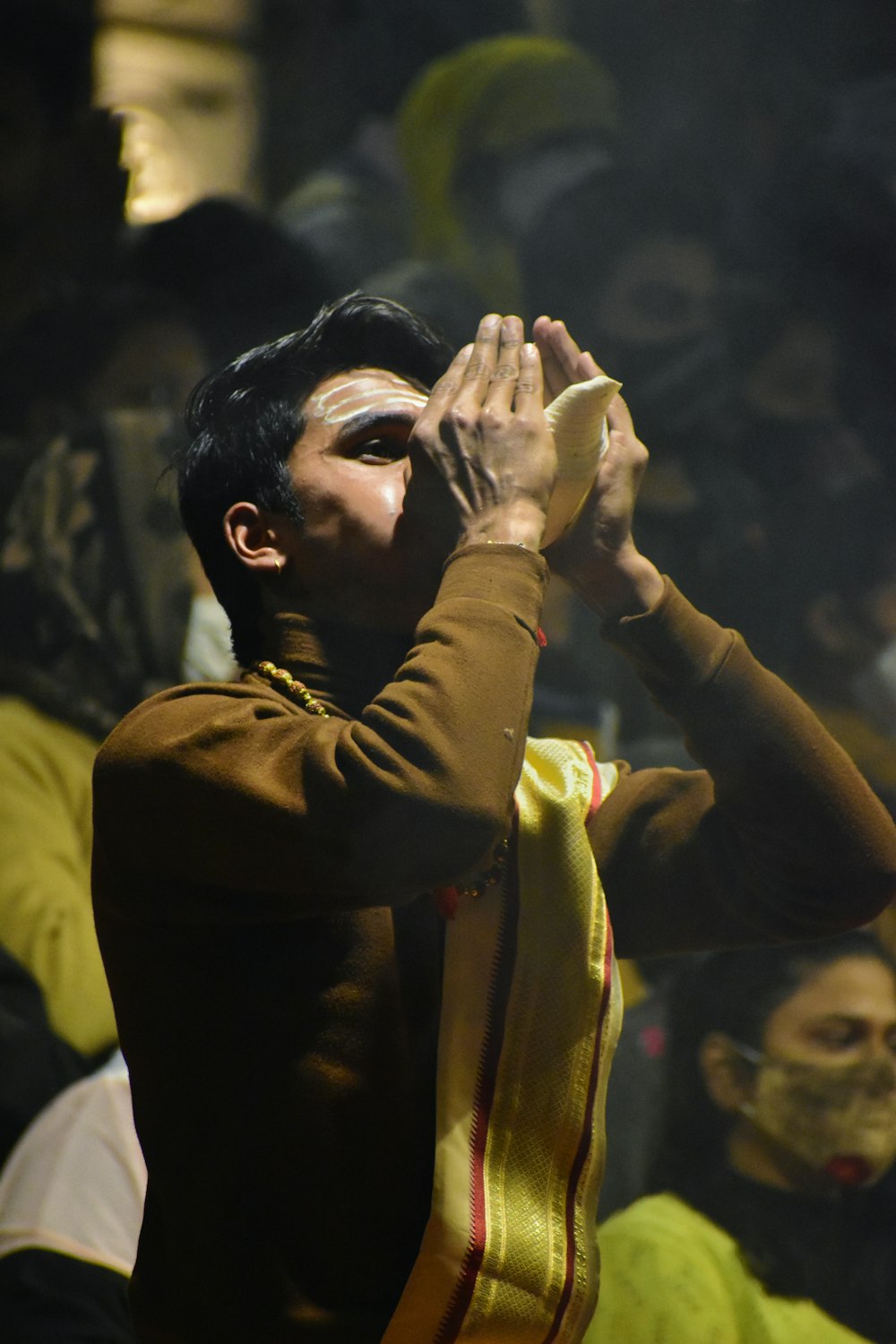 man in yellow long sleeve shirt covering his face