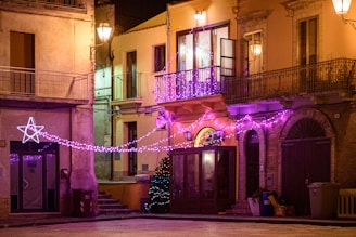 A joyful street in Villalba decorated with colorful Christmas lights at night.