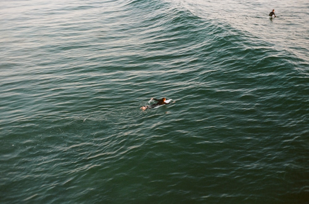 man in black swimming suit in the middle of ocean