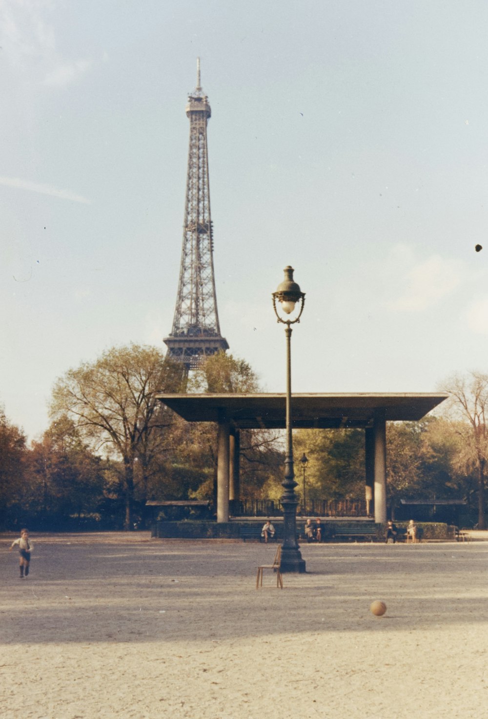 낮에 에펠탑 근처 공원을 걷는 사람들