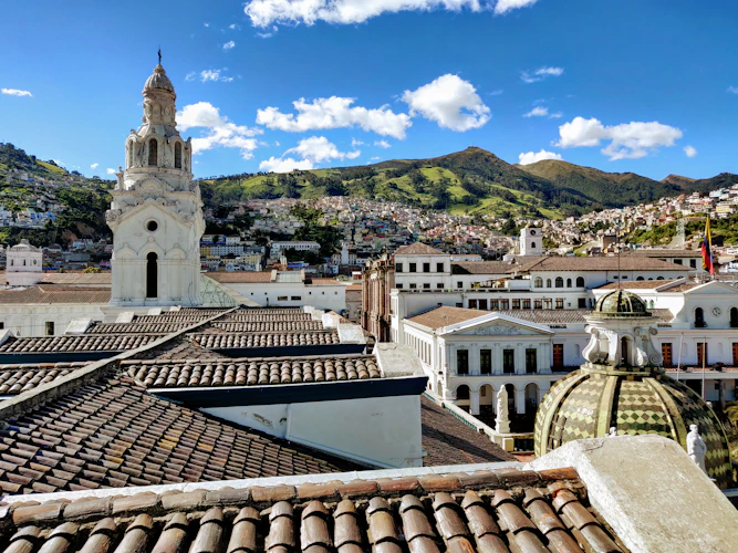 Quito old town rooftops with church tower and the Andes