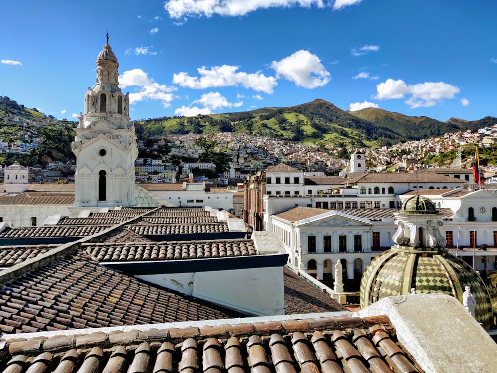 Edificio in cemento bianco e marrone vicino alla montagna verde sotto il cielo blu durante il giorno