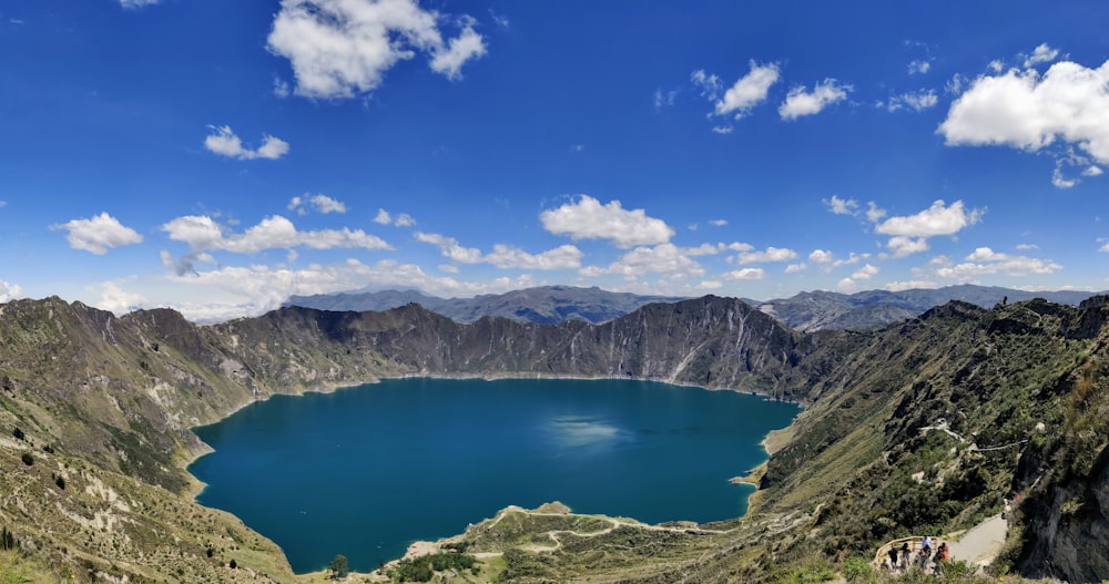 blue lake surrounded by mountains under blue sky during daytime