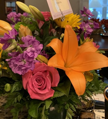 A vibrant flower bouquet next to a business card for a garden service.