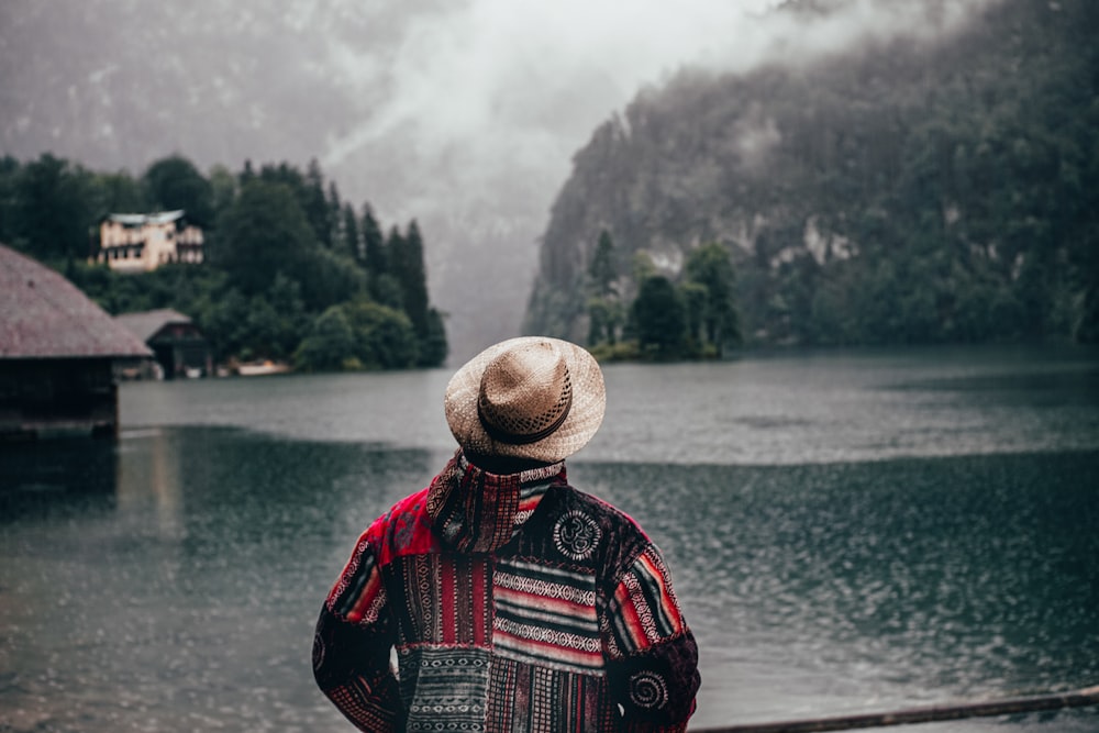 person in red black and white plaid shirt wearing brown straw hat standing near body of with with with with