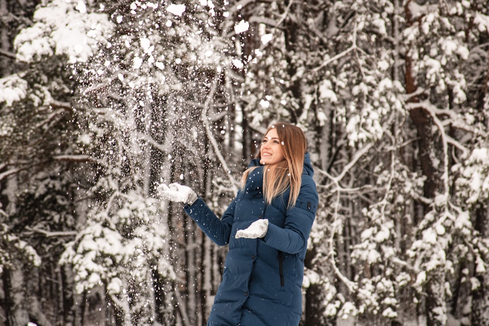 woman in blue jacket standing under white tree during daytime