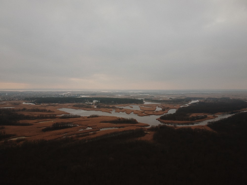 aerial view of brown field under cloudy sky during daytime