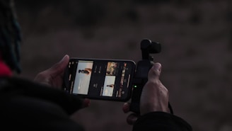 User holding a smartphone with framemaster ai cam app open, showing live composition guides on screen.