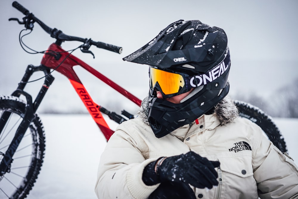 person in white jacket and black helmet riding on red and black motocross dirt bike