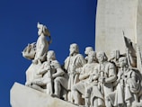 low angle photography of concrete statue under blue sky during daytime