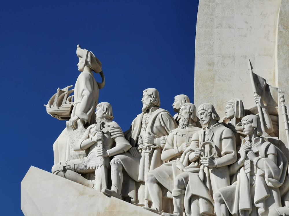 low angle photography of concrete statue under blue sky during daytime