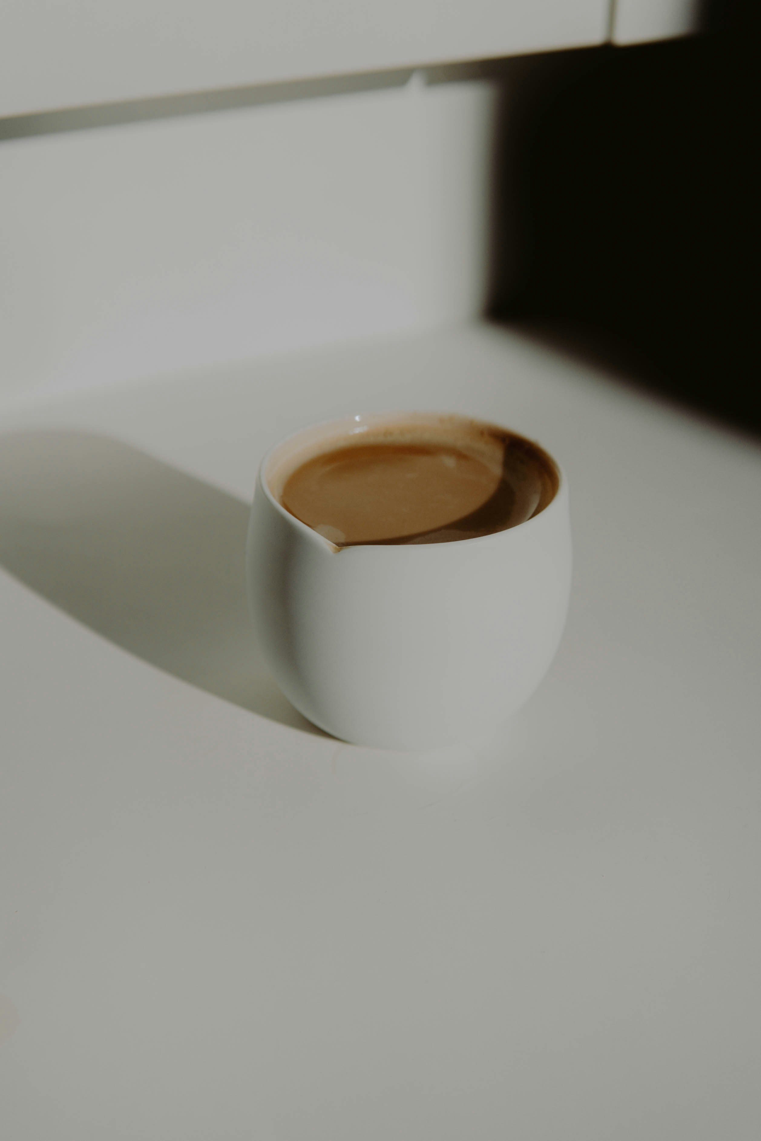 white ceramic mug with brown liquid