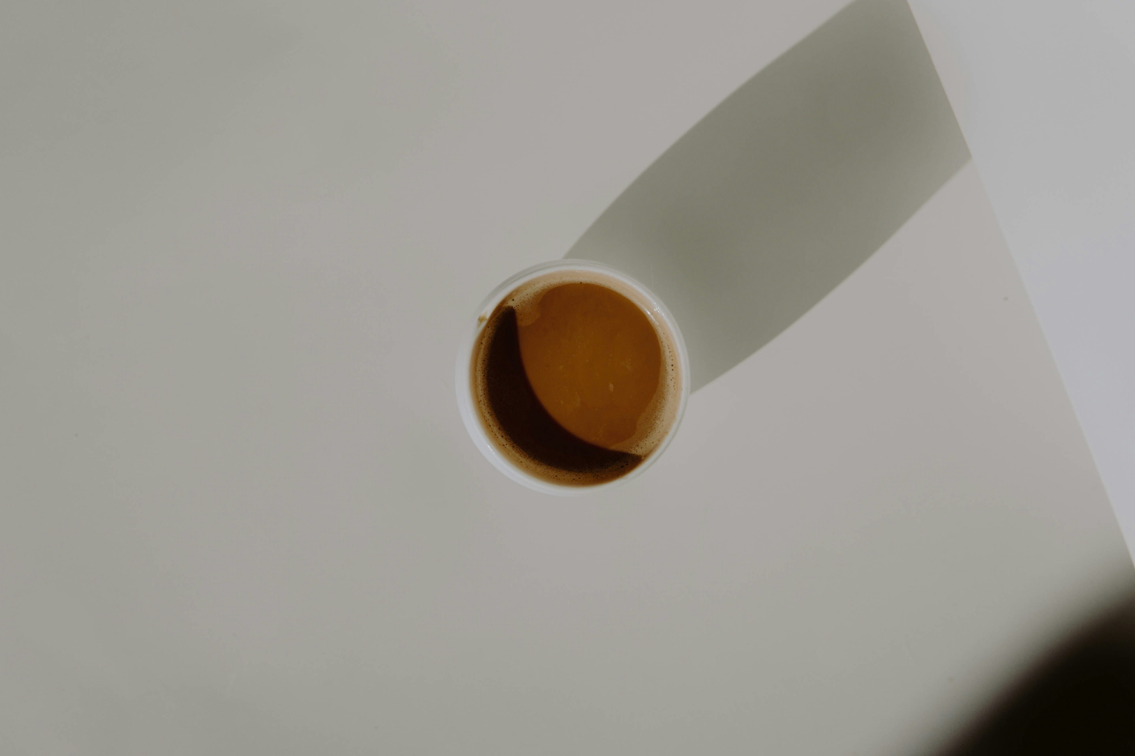 white paper cup with brown liquid