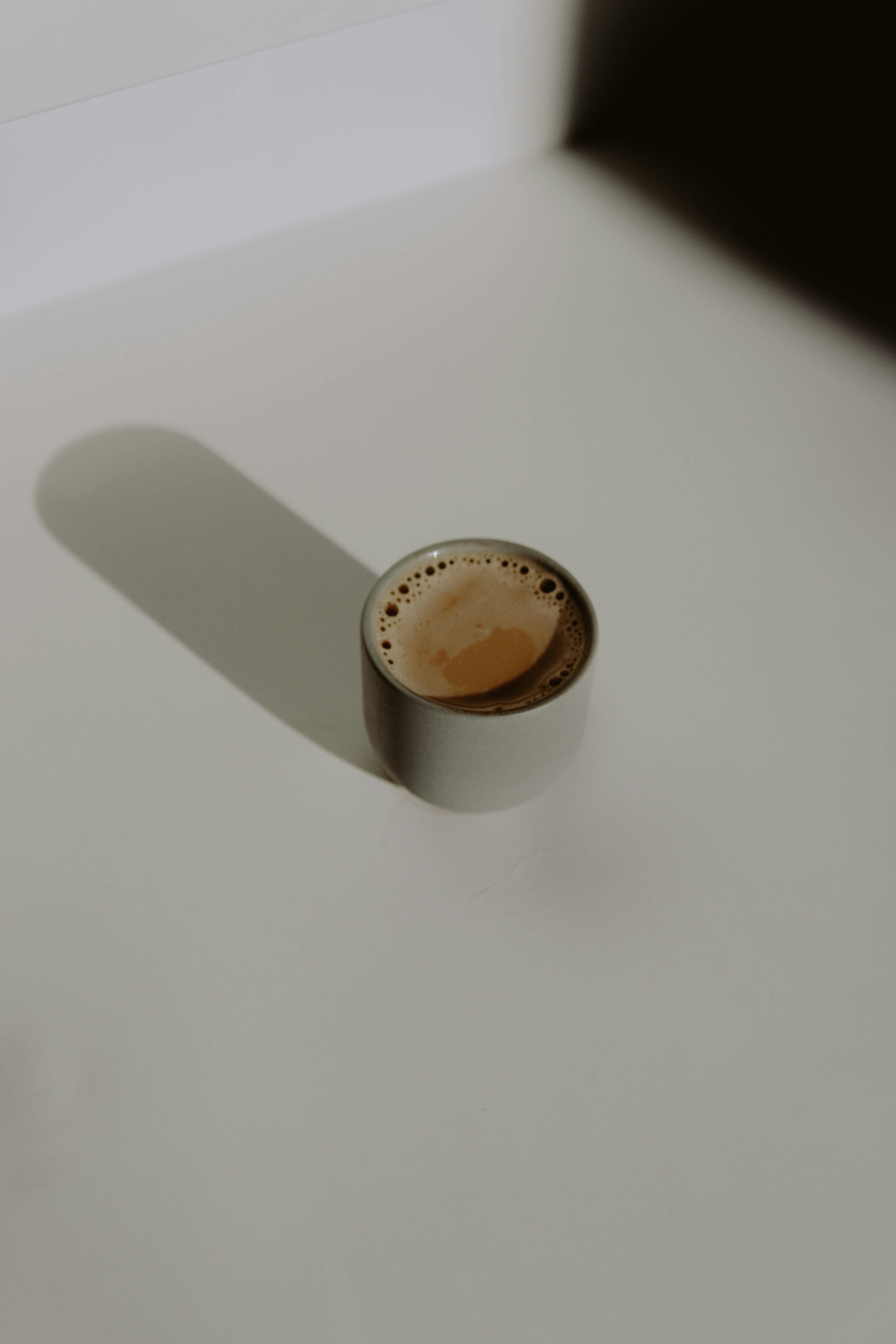 brown and white ceramic mug on white table