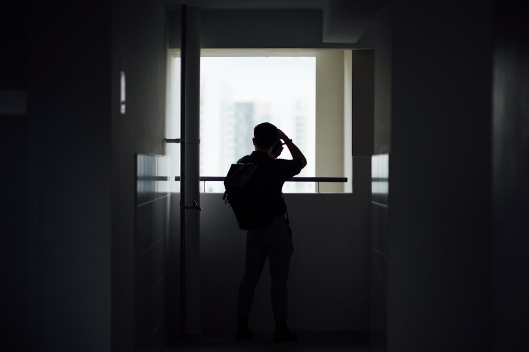 woman in black shirt standing in front of window