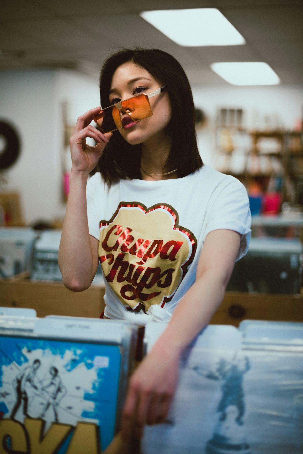 woman in white crew neck t-shirt holding brown sunglasses