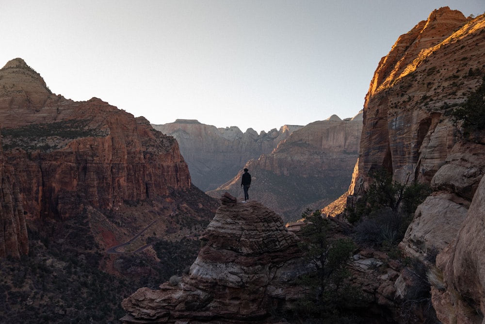 person sitting on rock formation during daytime