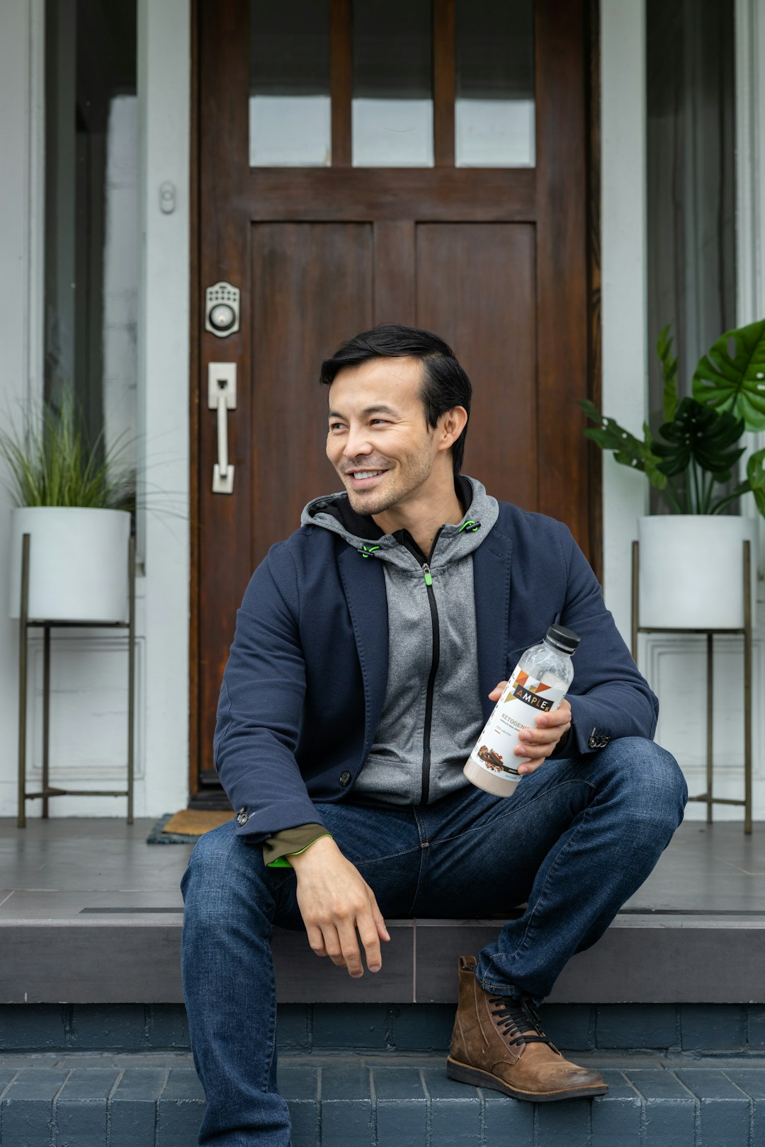 man in black zip up jacket holding white and brown can