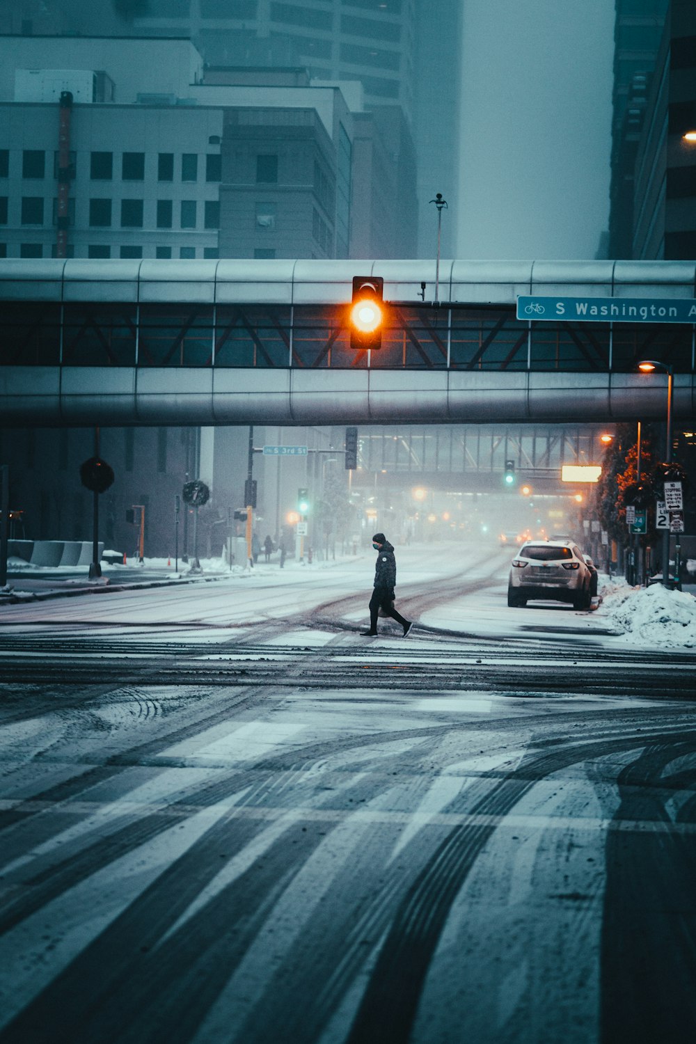 person in black jacket walking on street during night time