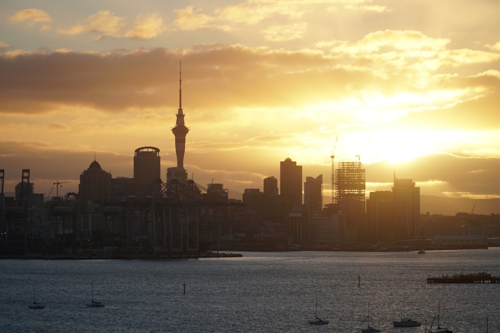 city skyline across body of water during sunset