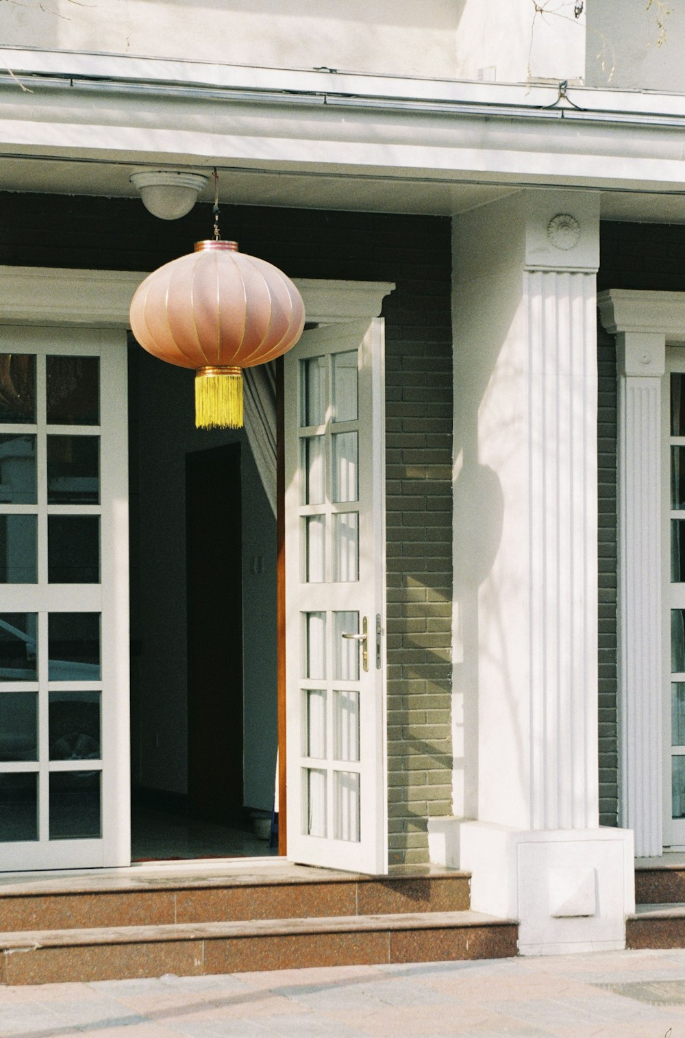 brown pendant lamp turned on near white wooden door