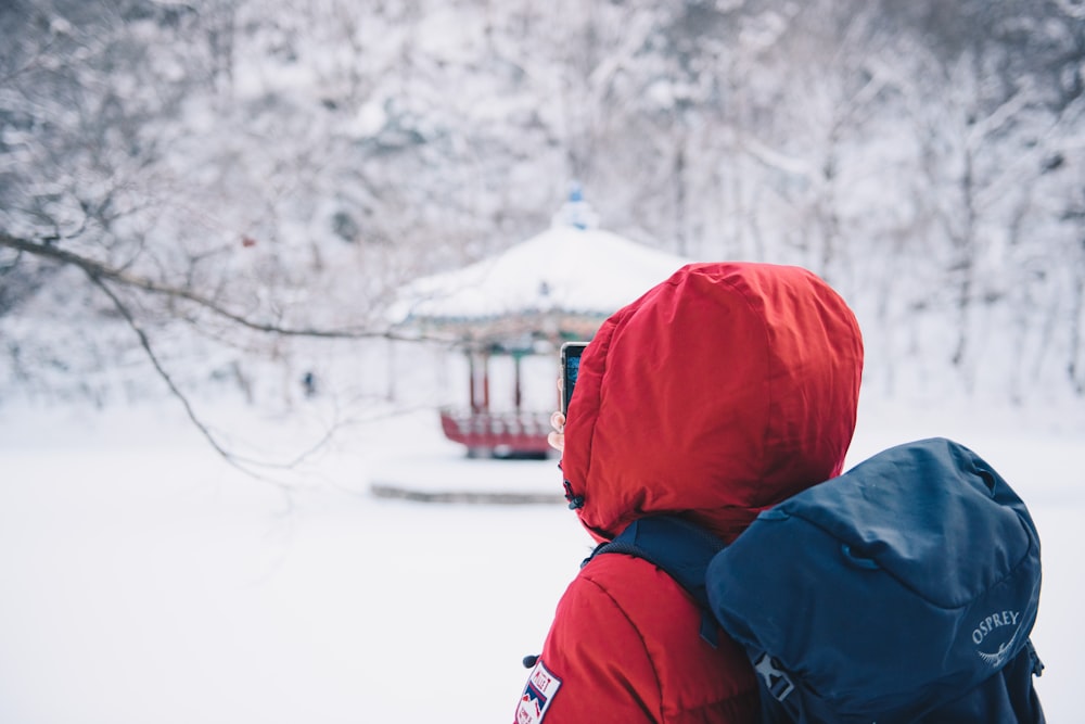 person in red hoodie and black backpack