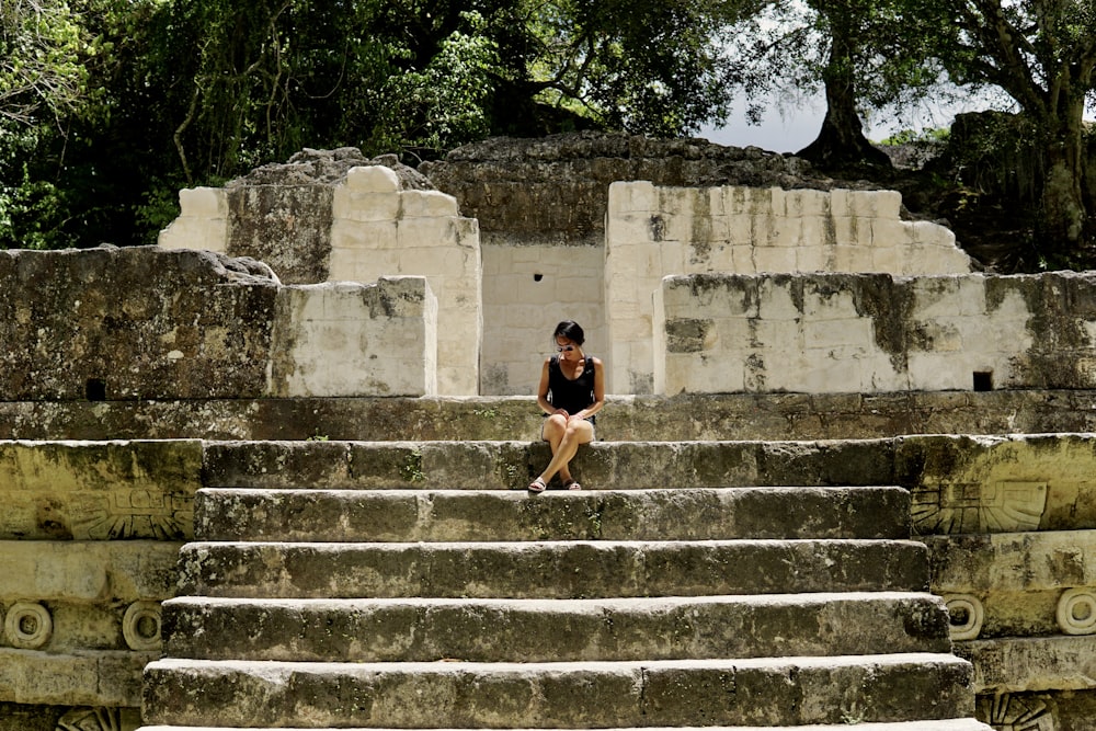 woman in black tank top and black shorts walking on gray concrete stairs