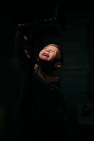 A joyful child reaching out with glowing hands in a softly lit room