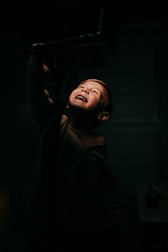 A joyful portrait of a child smiling, framed by soft natural light.