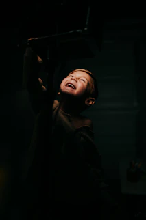 A spontaneous shot of a child playing joyfully in a cozy, warmly lit interior space.